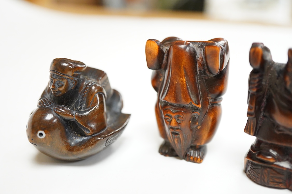 Four Japanese carved wood netsuke to include two elders and a novelty figure seated on a bird, largest 5cm high